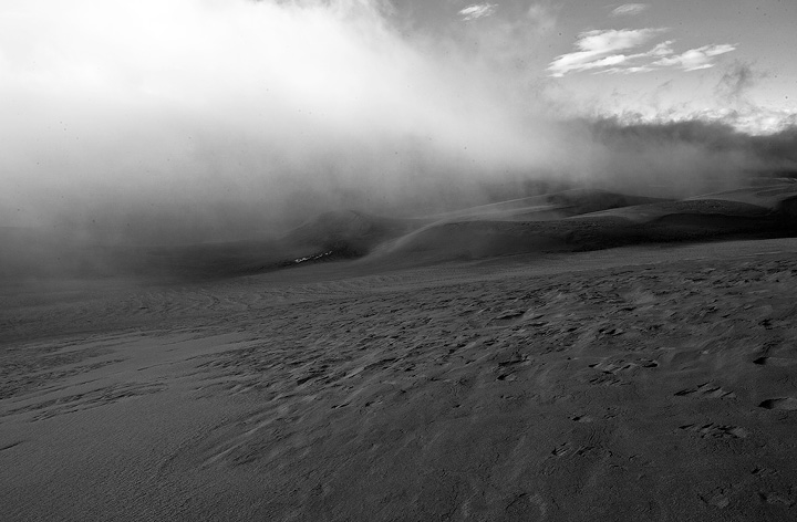 Black and white look at the fog streaming up the dunes.