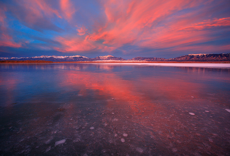 Frozen lake relfects an amazing sunset.