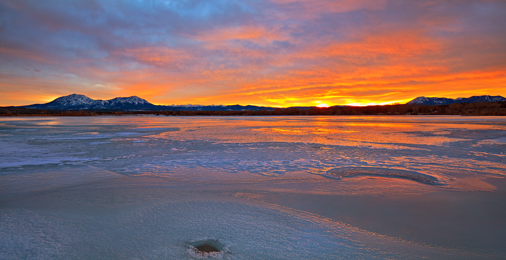 An amazing sunset unfolds from a frozen lake in Lathrop State Park.