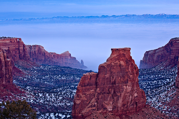 Fog creeps up the valley below the rim of the National Monument.