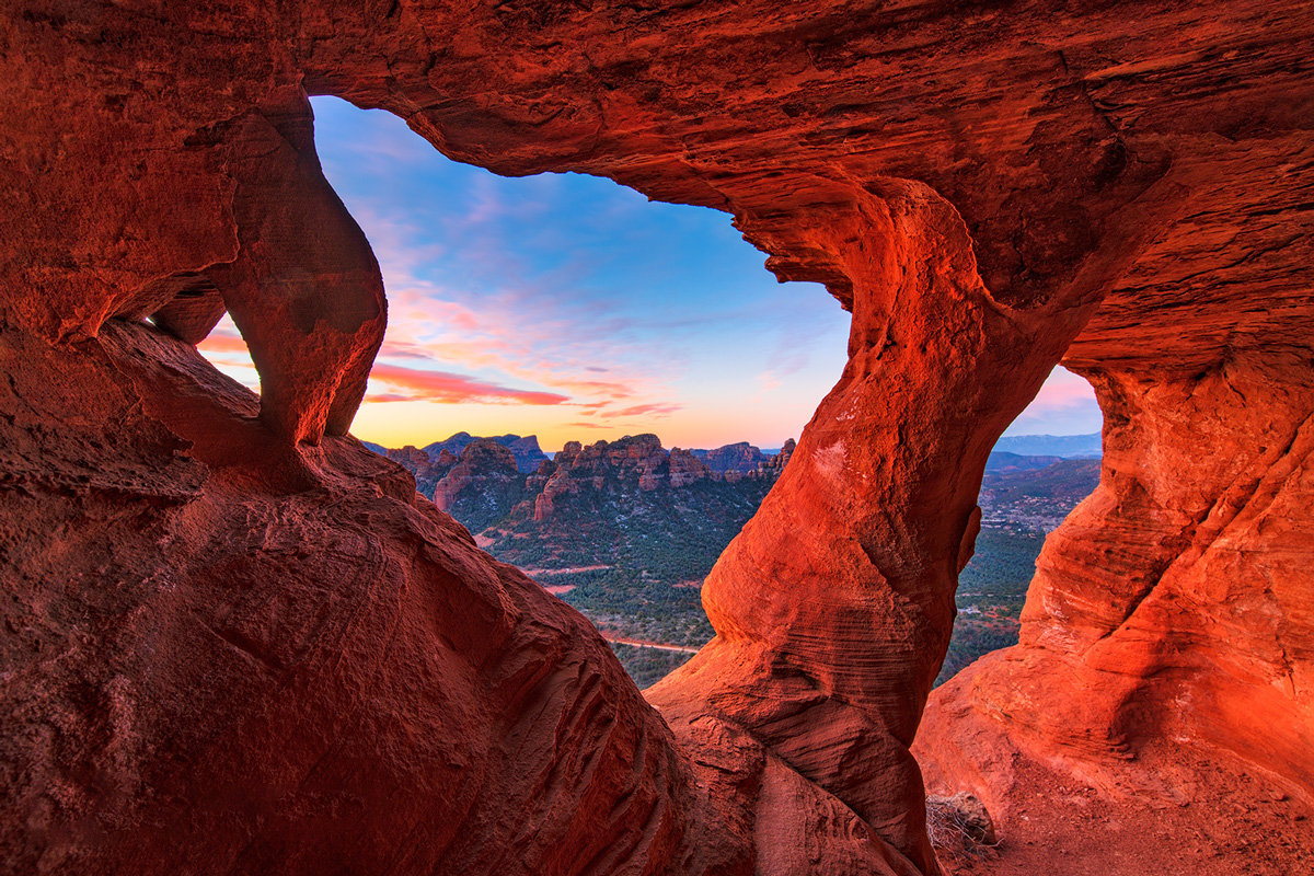 Looking out of a small cave high above Sedona at sunrise.